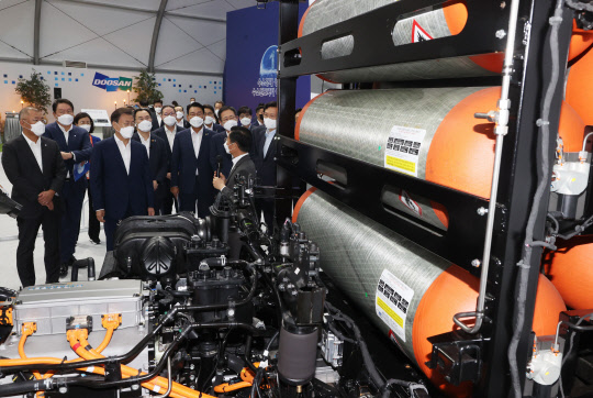 7일 인천시 서구 현대모비스 수소연료전지공장 신축 예정지에서 열린 '수소경제 성과 및 수소 선도국가 비전 보고' 대회와 기공식에 참석한 문재인 대통령과 정의선(왼쪽 첫번째) 현대자동차그룹 회장, 최태원(〃두번째) SK그룹 회장 등 기업인들이 수소트럭에 부착된 수소탱크에 대한 설명을 듣고 있다. 연합뉴스